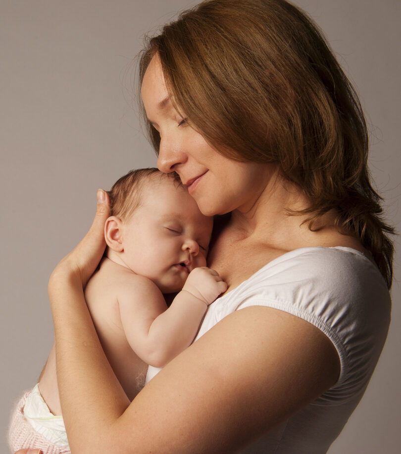 Confident woman stands in the wind, laughing as her hair blows around her face